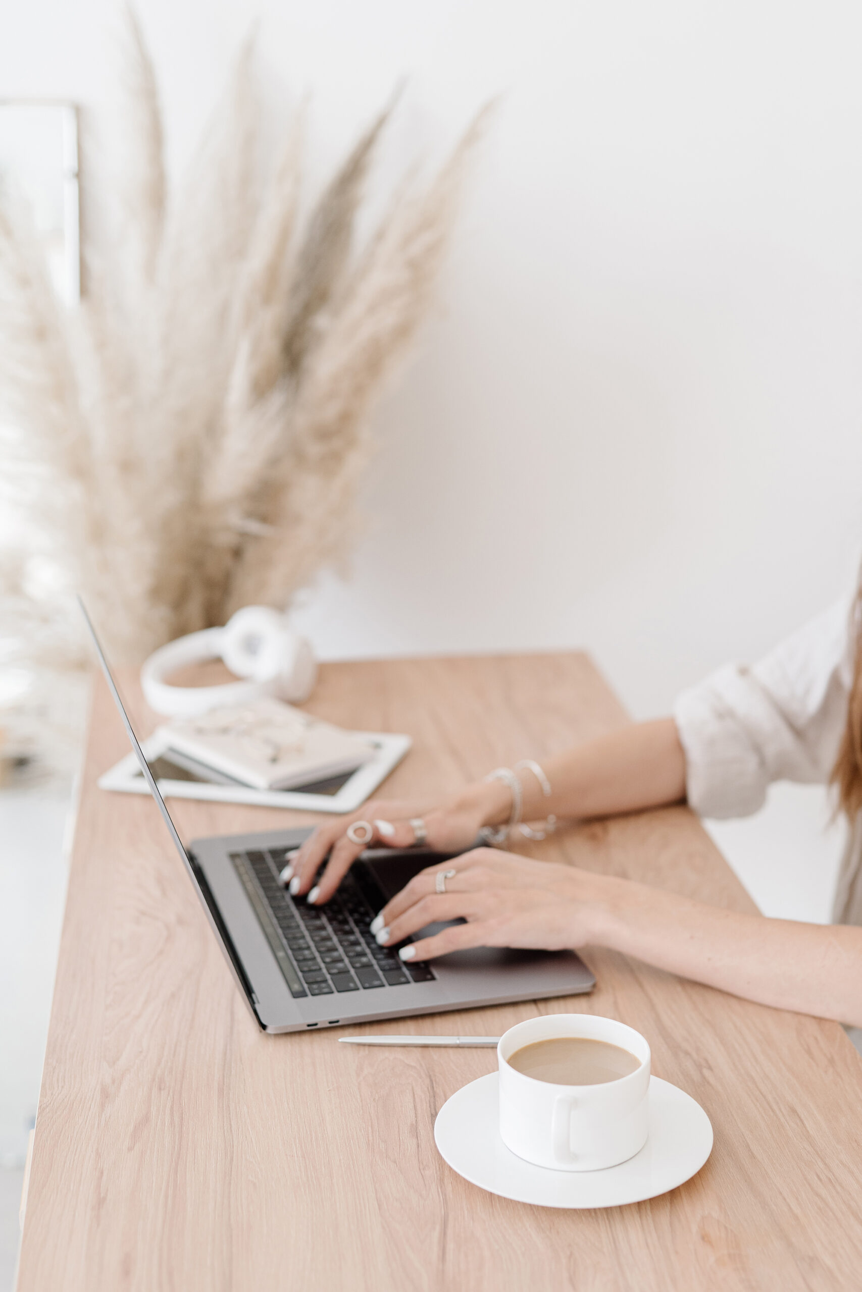 contact steffi. picture of a woman sitting on a wooden desk with a laptop and a cup of coffee