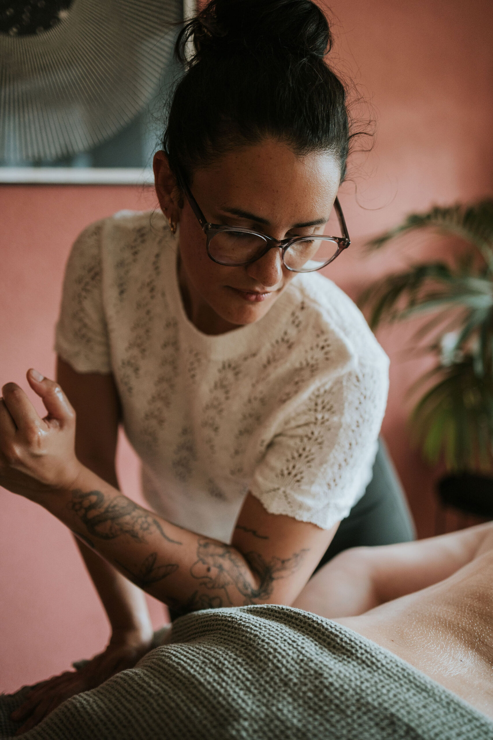 Steffi geeft een Rest & Restore sessie, met haar elleboog op de onderrug van een cliënt die op de behandeltafel ligt in de praktijkruimte in Rijswijk